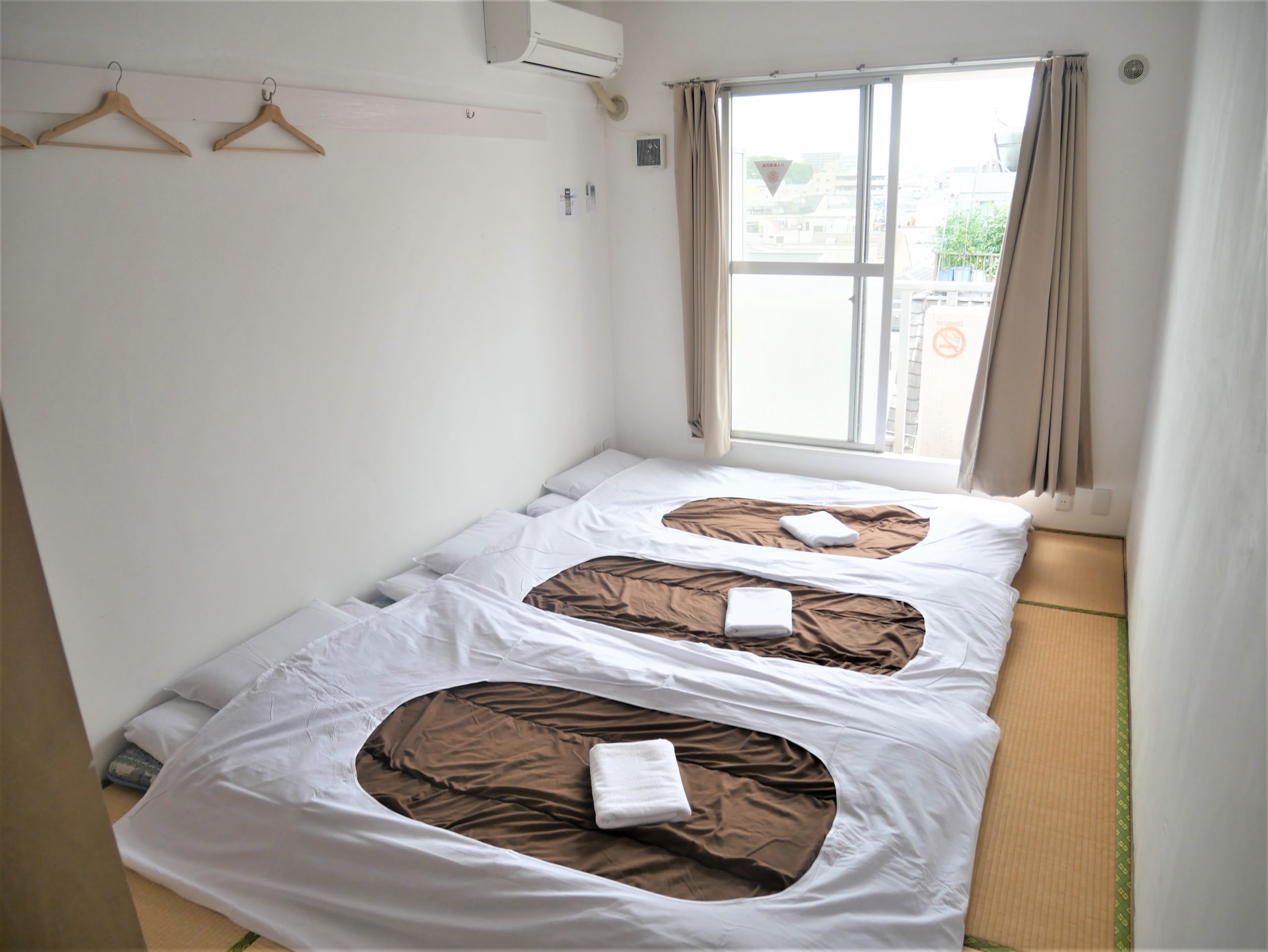 "Japanese Style Triple Room with tatami flooring and futons, ideal for families and groups at Sakura Hotel Nippori in Tokyo"